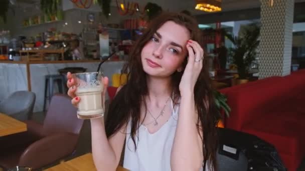Mujer Joven Sentada Café Con Vaso Café Batido Bebiéndolo — Vídeo de stock
