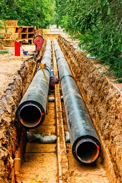 Dos nueva tubería de tubo de agua de calefacción en trinchera cubierta con aislamiento de calor negro — Foto de Stock