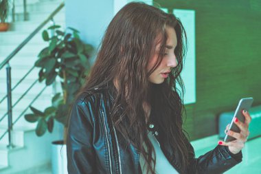 Modern kız smaprtphone ile mesaj atıyor, eline alıyor.