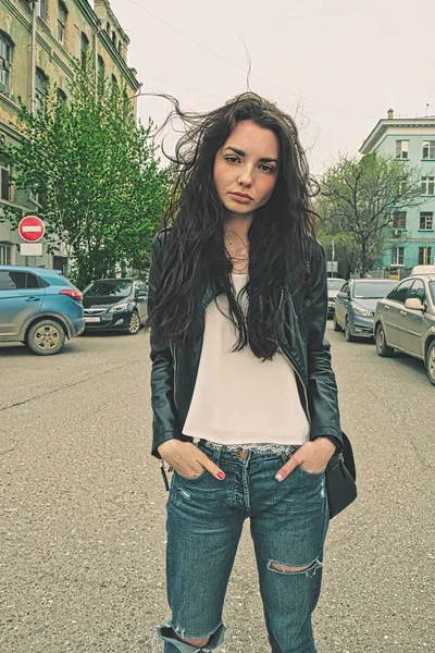 Modern girl standing outside in rip-jeans in the center of the street — Stockfoto