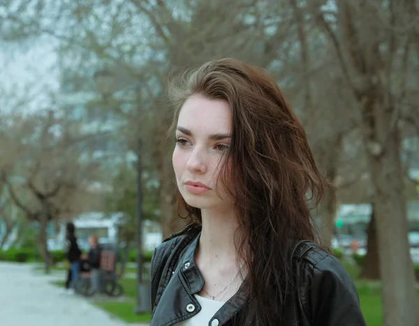 Calm girl with windy hair headshot in green tones — Stockfoto