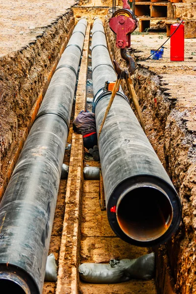 Trabajos de construcción. Reparación de comunicaciones. Trabajos de construcción. Reparación de comunicaciones. La trinchera en las calles de la ciudad y nuevas tuberías para la reparación de tuberías — Foto de Stock