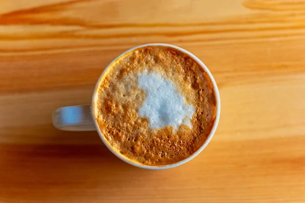 Tazza di cappuccino su un tavolo di legno In luce naturale vista dall'alto . — Foto Stock