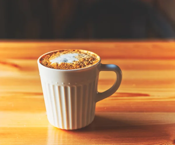 Mug of cappuccino on a wood table In natural light side view. — Stock Photo, Image