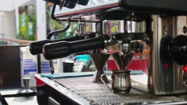 Espresso kahve ön planda yavaş çekimde profesyonel kahve makinesinden metal cama ve bulanık arka plan barista çalışma