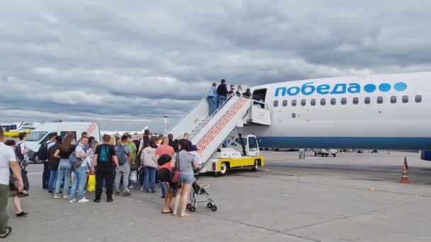 Moscow, Russia, Aug 22, 2019: Passengers boarding on the aircraft of lowcoster airline company Pobeda the only lowcoster on Russian market pan shot — Stock Video