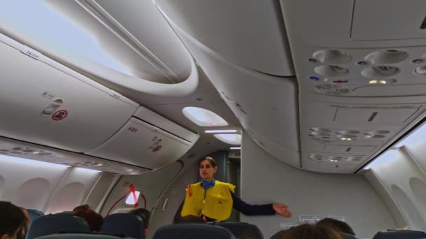 Moscow Russia - Aug. 22 2019: Cabin crew shows how to use life vest before departure on the board of Pobeds airliner. Pobeda is the only lowcoster company on Russian market — Stock Video