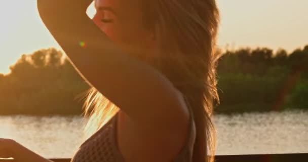 Retrato de uma mulher loira feliz com cabelo liso retroiluminado pelo sol . — Vídeo de Stock