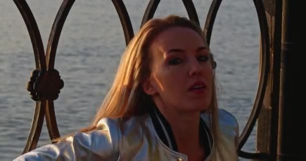 Vackra 30s kvinna spela och kamma hennes blonda hår i solnedgången ljus headshot — Stockvideo