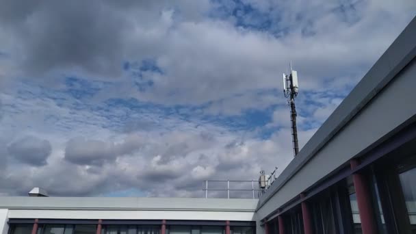 Nuvens voando sobre o telhado do edifício moderno com transientes celulares móveis timelapse — Vídeo de Stock