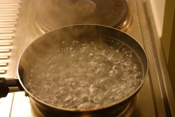 Water in the pot boils close up with steam above — Stock Photo, Image