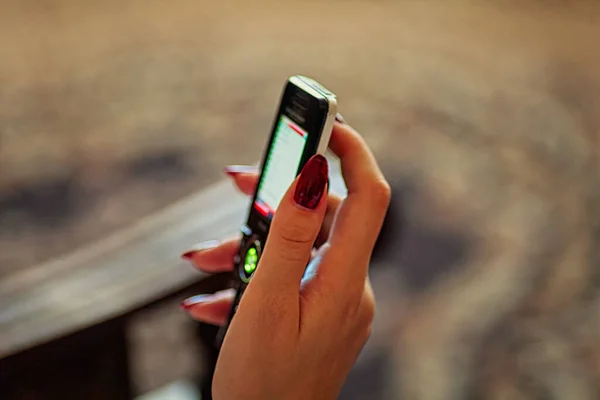 Vrouwelijke hand met behulp van een smartphone. Ondiepe scherptediepte — Stockfoto