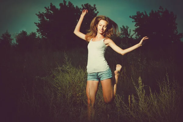 快乐喜怒无常的女士在外面高高的草地上 在夜空中跳着欢快的芭蕾舞 — 图库照片