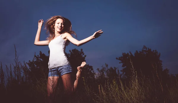 一个骄傲自满的姑娘在草地上跳舞 她的胳膊抬起来伸了伸 — 图库照片