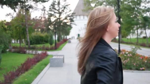 Blond dame draaien in het park met haar haar slingeren oround — Stockvideo