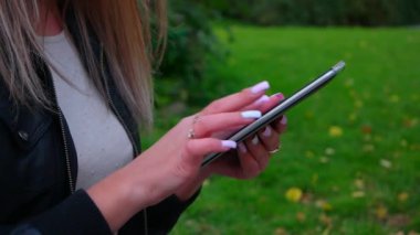 Parktaki tablet bilgisayarda mesaj atan kadın.