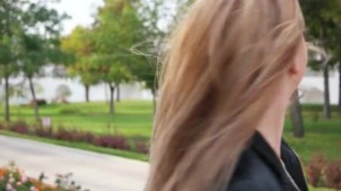 Sarışın kadın sokakta dans ediyor. Yakın çekim vesikalığı..