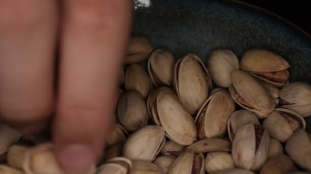Seller is holding one of Pistachios over the full surface of it. — Stock Video