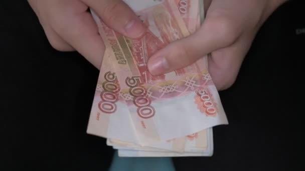 Um menino está segurando um monte de rublos russos notas em suas mãos e contá-lo — Vídeo de Stock