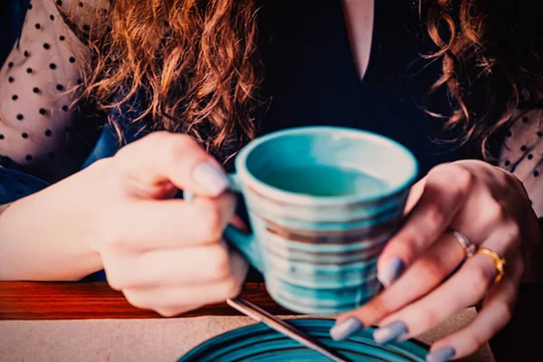 Les jeunes filles mains tiennent une tasse de thé en céramique — Photo