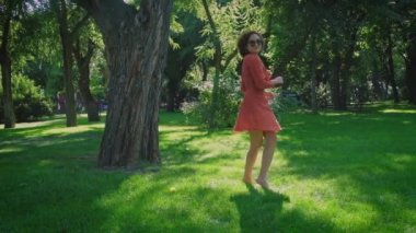 Hoş Asyalı kız parkta poz veriyor. Güneş lekesi üzerinde retro tarzı giyinmiş.