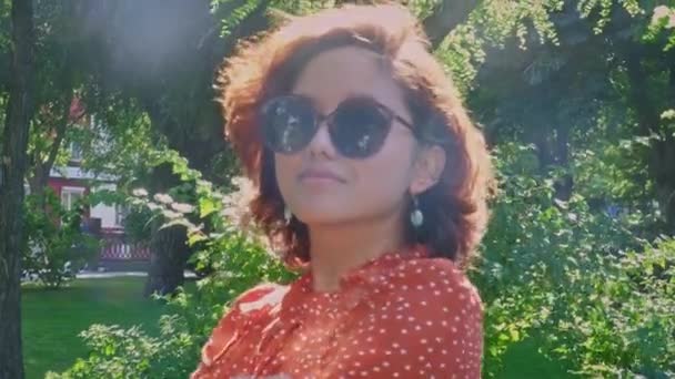 Una jovencita de Asian Tpa posa en gafas de sol de estilo retro en el parque — Vídeo de stock