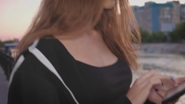 Nice brown haired girl in the street using a tablet pc, copyspace. — Stok Video