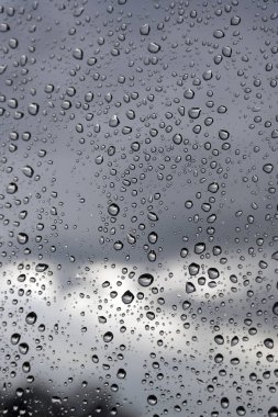 Su damlaları bir pencere camına yağmurlu bir gün
