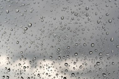 Su damlaları bir pencere camına yağmurlu bir gün