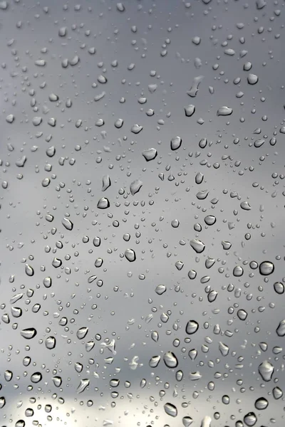 Σταγόνες νερού σε ένα γυάλινο παράθυρο, βροχερή μέρα — Φωτογραφία Αρχείου
