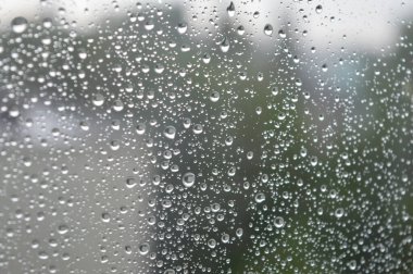 Yağmurlu bir günde pencereye yağmur damlaları yağar. Sığ DOF