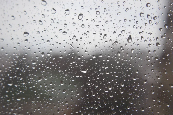 Gotas de lluvia en la ventana, día lluvioso — Foto de Stock