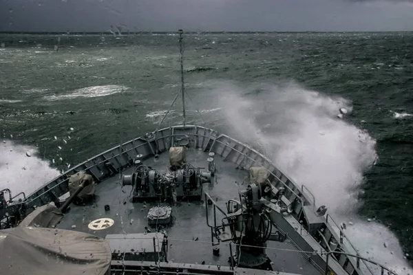 Ship in sea storm. Storm at Baltic sea. Warship training in the Baltic Sea during a storm. NATO military ship in Baltic sea, Latvia. NATO military ship at sea during a storm. view from ships the bow.