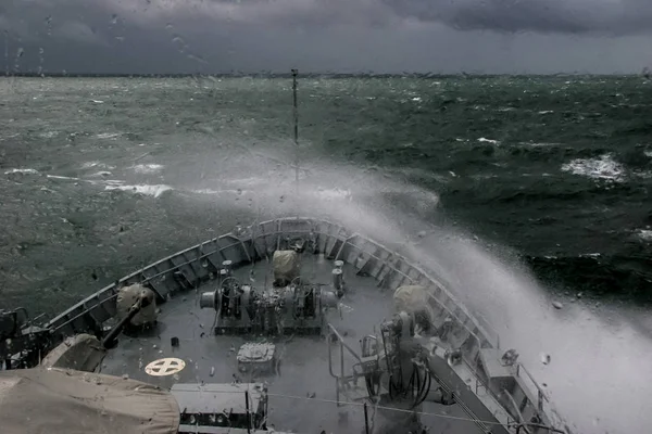 Ship in sea storm. Storm at Baltic sea. Warship training in the Baltic Sea during a storm. NATO military ship in Baltic sea, Latvia. NATO military ship at sea during a storm. view from ships the bow.