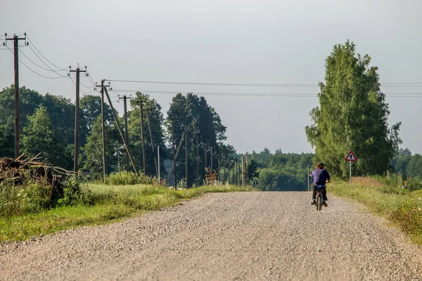 Landscape with rural road and man on moped.. — Stock Photo, Image