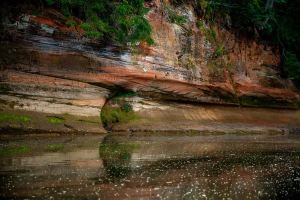 Roter Sandsteinfelsen in der Nähe des Flusses. — Stockfoto