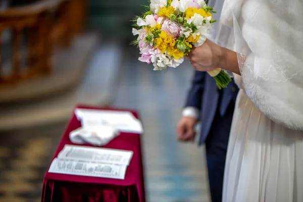 Bouquet of flowers in the hand of the bride during the marriage — Stock Photo, Image