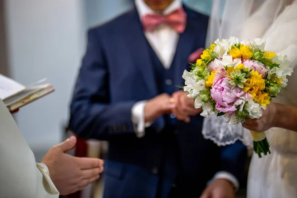 Bouquet of flowers in the hand of the bride during the marriage — Stock Photo, Image