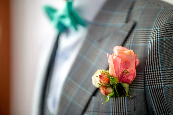 Roze roos in de bruidegom in zak van jas Stockfoto