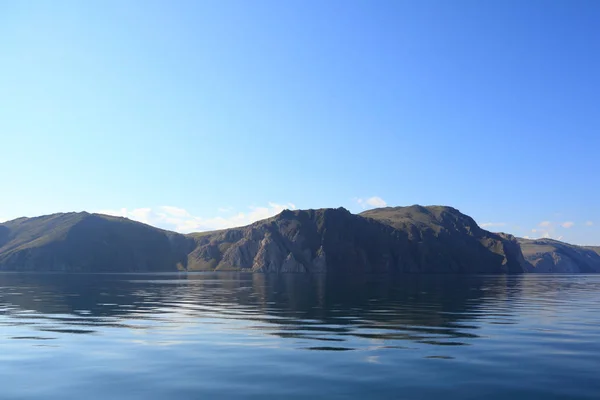 贝加尔湖的岩石岸边反映在水汪汪的水面上 — 图库照片
