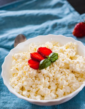 Sağlıklı kahvaltı: çilek masada beyaz kase süzme peynir
