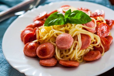 masada beyaz tabak içinde kızarmış Sosisli makarna spagetti