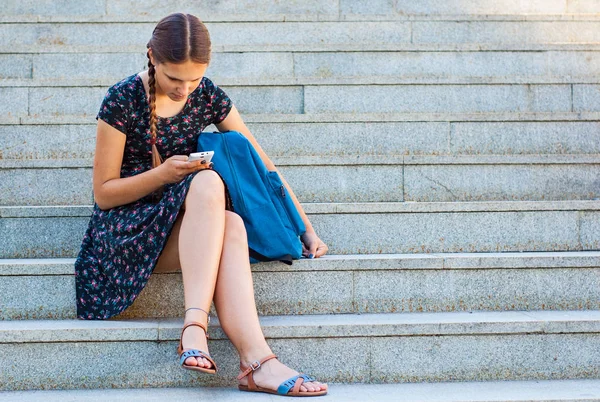 階段の上に座って 携帯電話で見ている 代の少女 — ストック写真