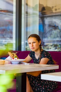 Bir genç Genç kız eğleniyor kafede dondurma yeme