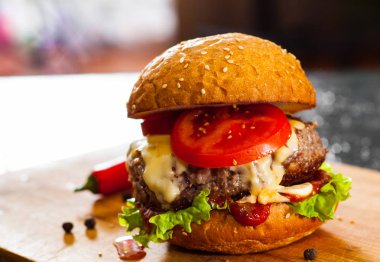 Burger ahşap tahta üzerinde. koyu arka plan üzerinde kopya alanı ile.