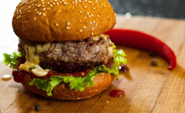 Burger ahşap tahta üzerinde. koyu arka plan üzerinde kopya alanı ile.