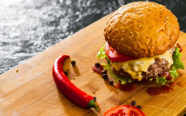Burger ahşap tahta üzerinde. koyu arka plan üzerinde kopya alanı ile.