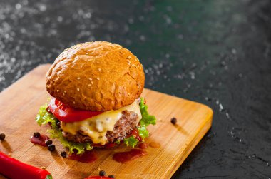 Burger ahşap tahta üzerinde. koyu arka plan üzerinde kopya alanı ile.