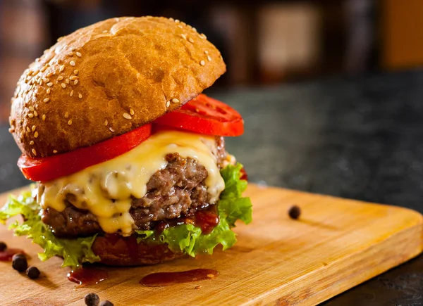Burger ahşap tahta üzerinde. koyu arka plan üzerinde kopya alanı ile.