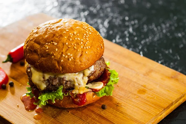Burger ahşap tahta üzerinde. koyu arka plan üzerinde kopya alanı ile.